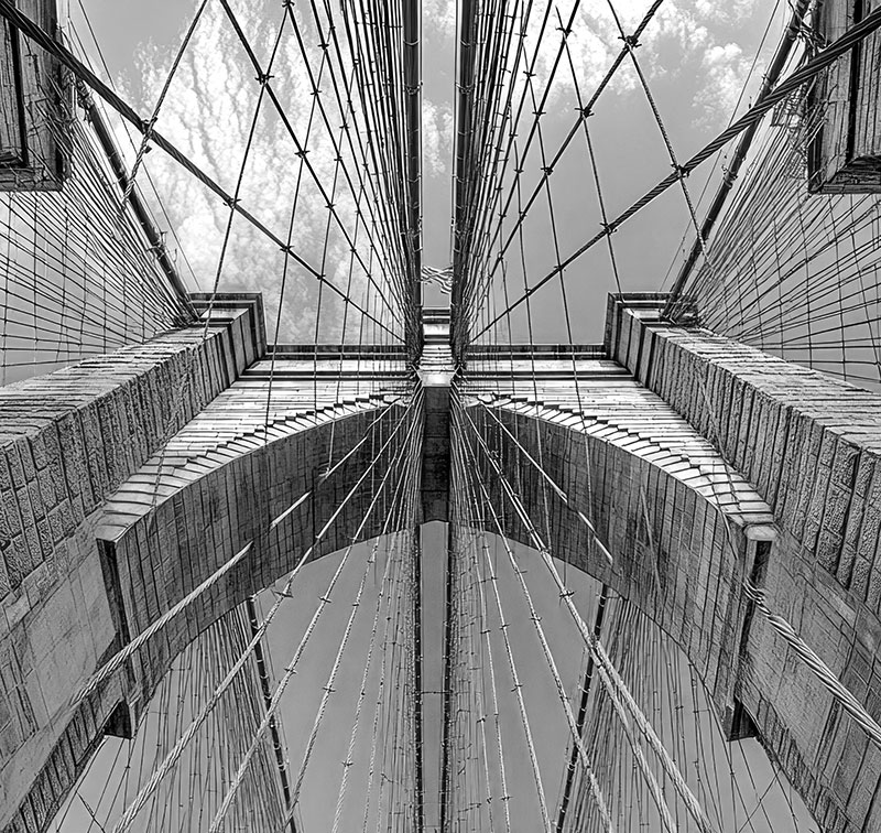 looking up at brooklyn bridge in black and white